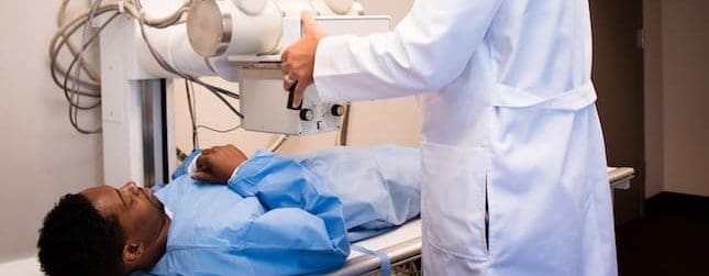 doctor scanning patient laying on bed