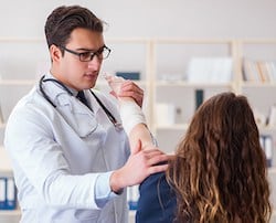 orthopedic doctor in atlanta helping woman's arm